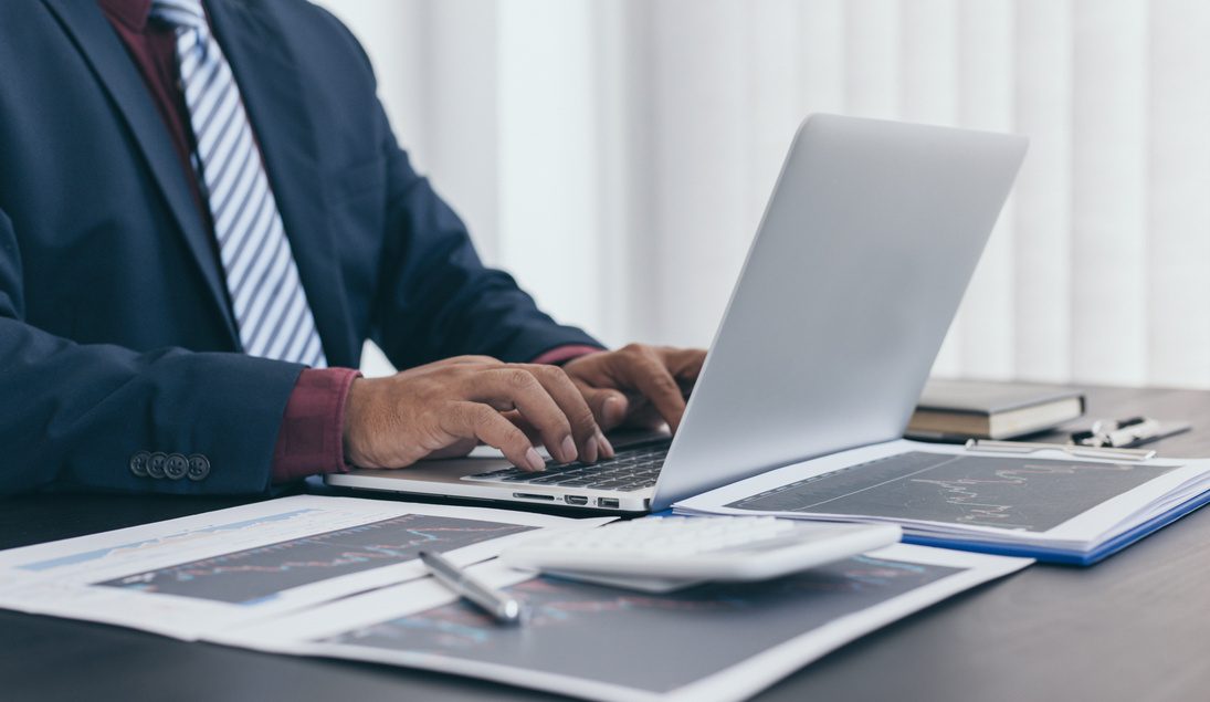 A leader reviewing documents and a laptop at a desk